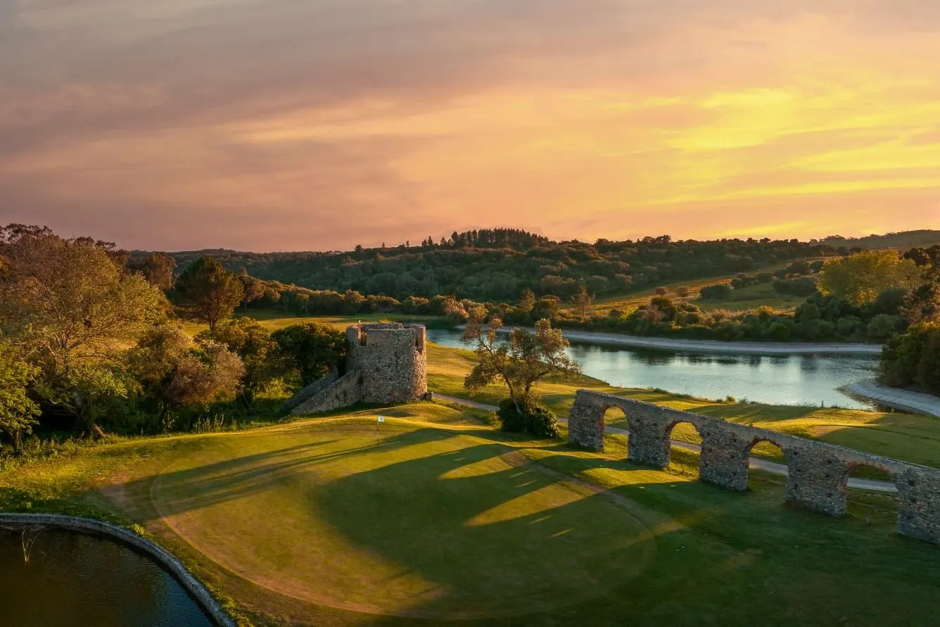 Sunset over the green hills and old stone arches around Penha Longa, near Lisbon